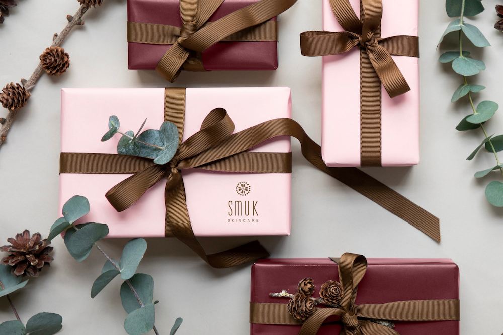 Luksus adventskalender med eksklusive hudplejeprodukter smukt indpakket i rosa og bordeaux gaver med bånd og eucalyptus